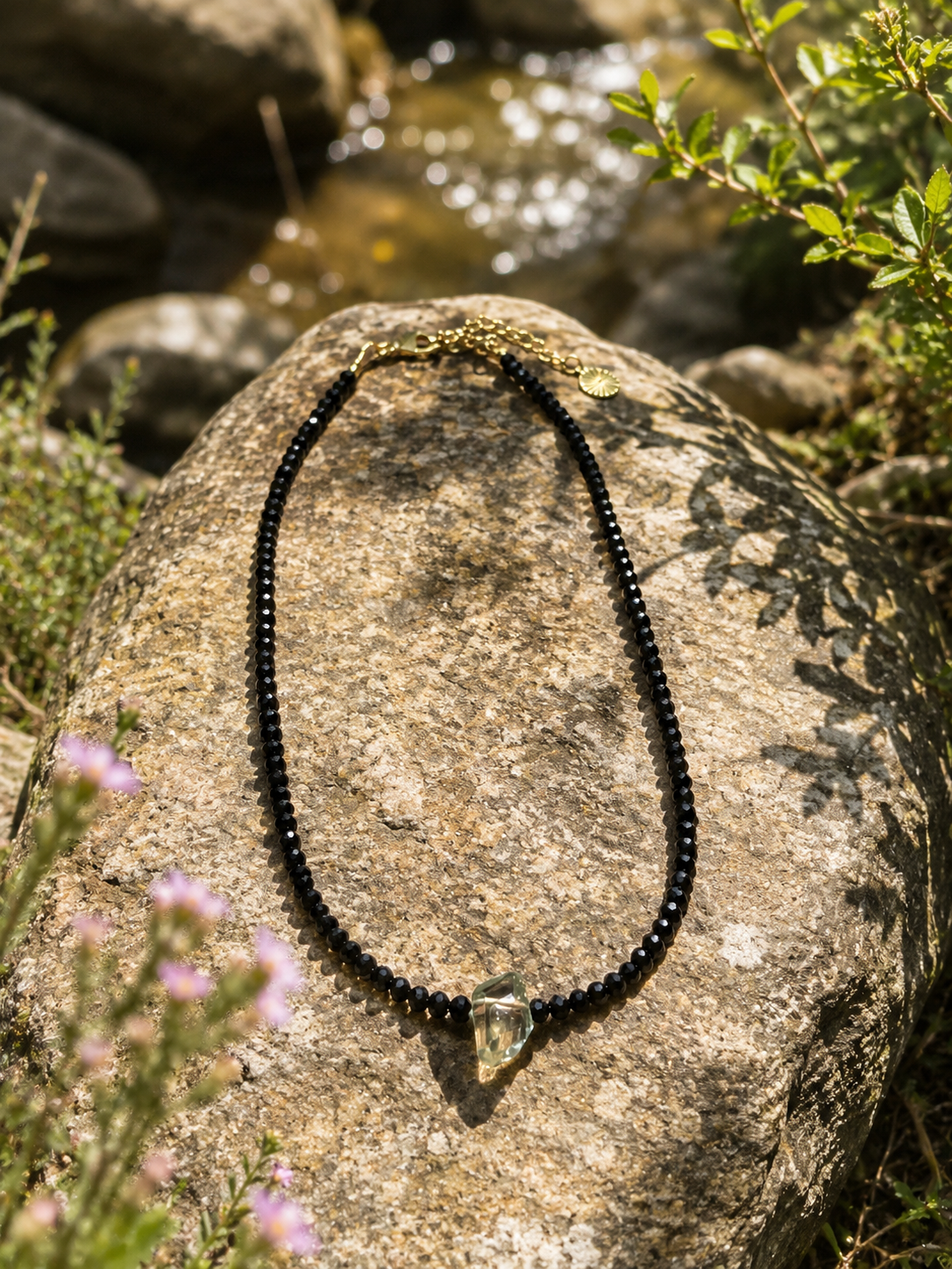 Collier Aurora spinelle et prasiolite posé sur un rocher à Saint-Tropez — Thérapierres
