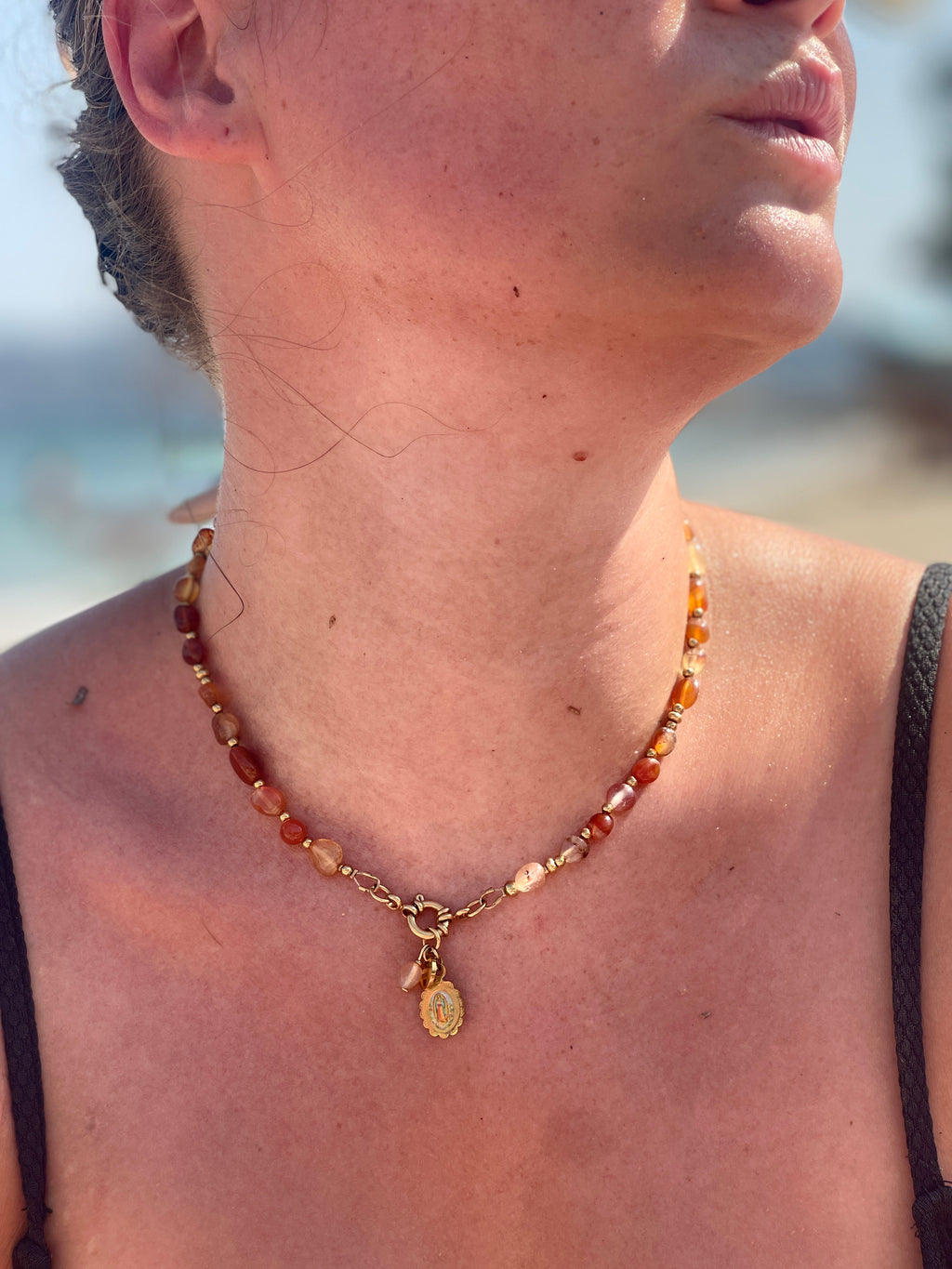 Collier cornaline, médaille Notre-Dame de Guadalupe, porté à la plage — Thérapierres, Golfe de Saint-Tropez