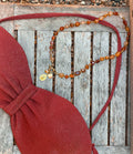 Collier cornaline, médaille Notre-Dame de Guadalupe, posé à plat — Théra'Pierres, Golfe de Saint-Tropez